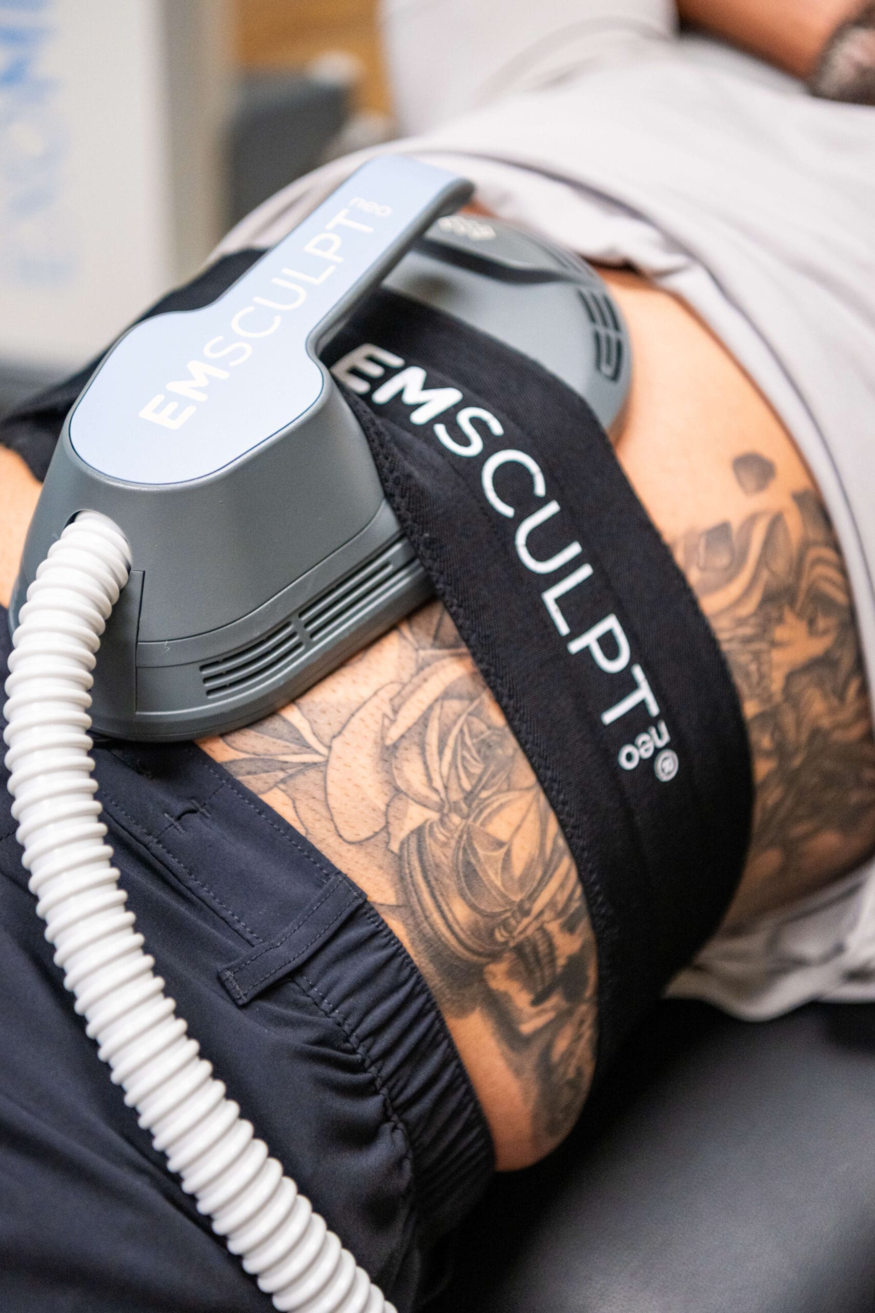 Details of an Emsculpt machine on a man at Compass Rose Health and Wellness